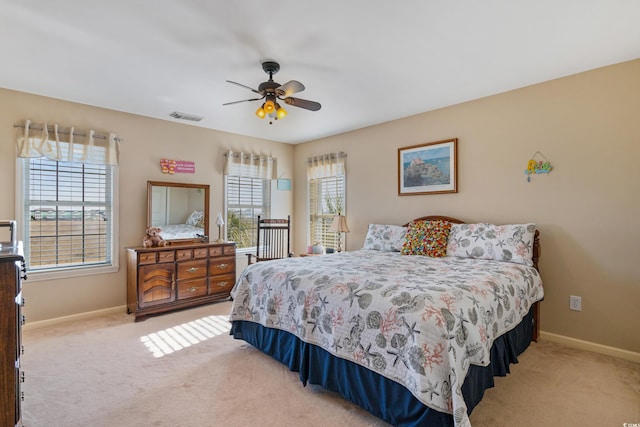 bedroom with ceiling fan, light colored carpet, visible vents, and baseboards