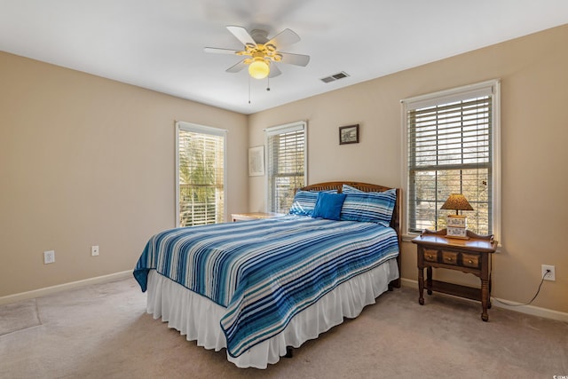 bedroom featuring a ceiling fan, baseboards, visible vents, and light carpet