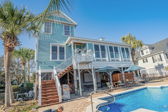 back of property featuring a fenced in pool, stairs, a patio, and fence