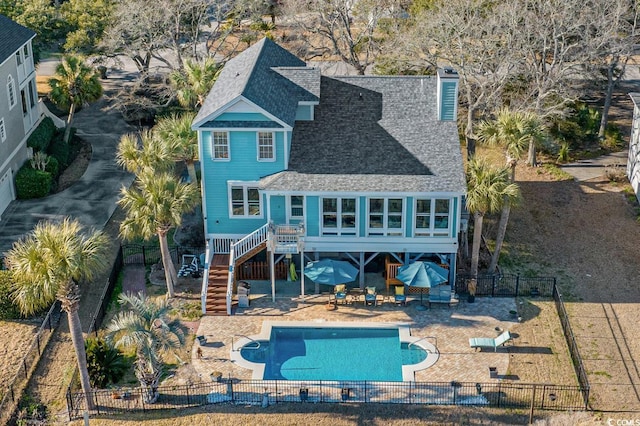 back of property featuring stairs, a patio, a fenced backyard, and a shingled roof