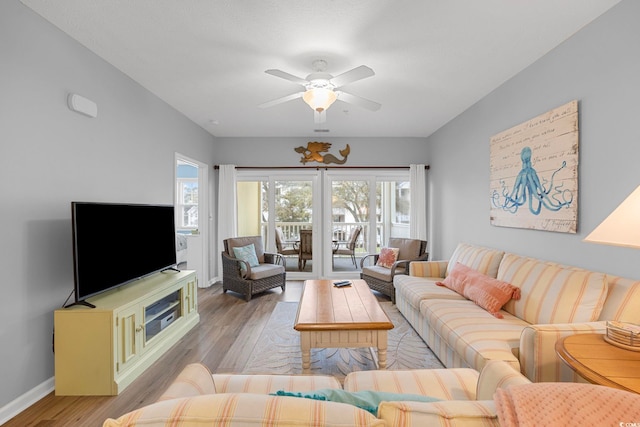 living room with light wood-type flooring, baseboards, and a ceiling fan