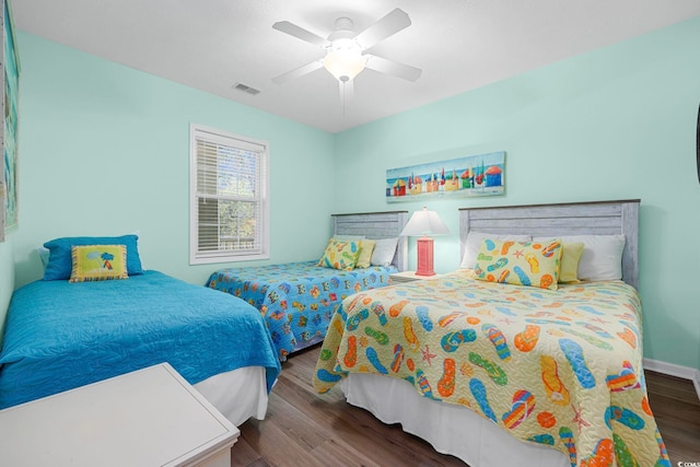 bedroom featuring visible vents, baseboards, wood finished floors, and a ceiling fan