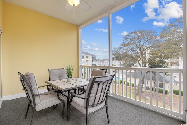 balcony featuring outdoor dining area, a ceiling fan, and a residential view