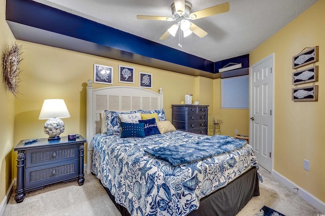 carpeted bedroom featuring baseboards, a textured ceiling, and a ceiling fan