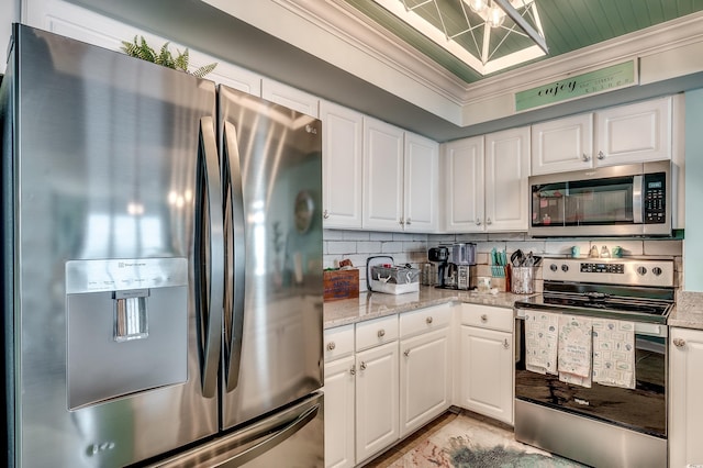 kitchen featuring stainless steel appliances, tasteful backsplash, ornamental molding, and white cabinets