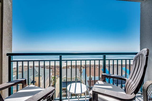 balcony featuring a view of the beach and a water view