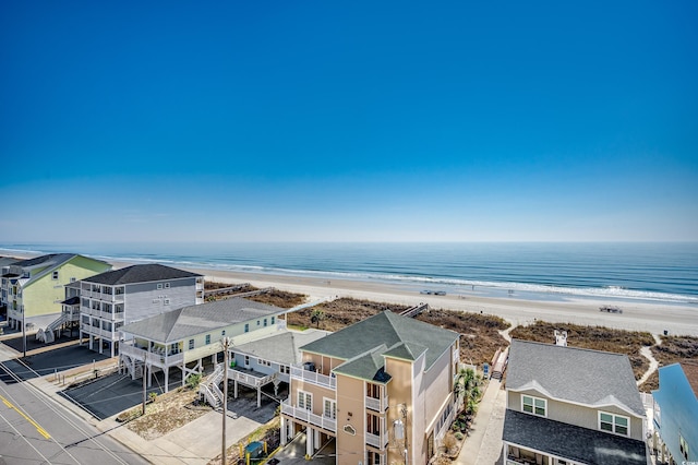 drone / aerial view featuring a residential view, a water view, and a beach view