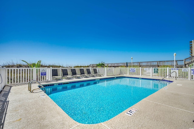 community pool featuring a patio and fence