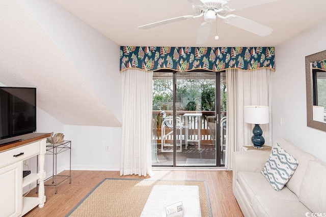living room with wood finished floors and a ceiling fan
