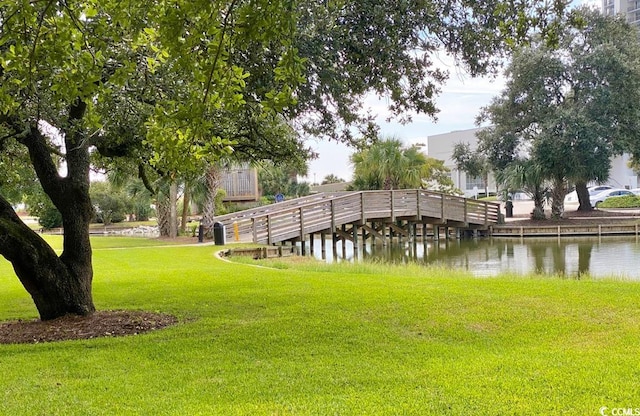 view of home's community featuring a lawn and a water view