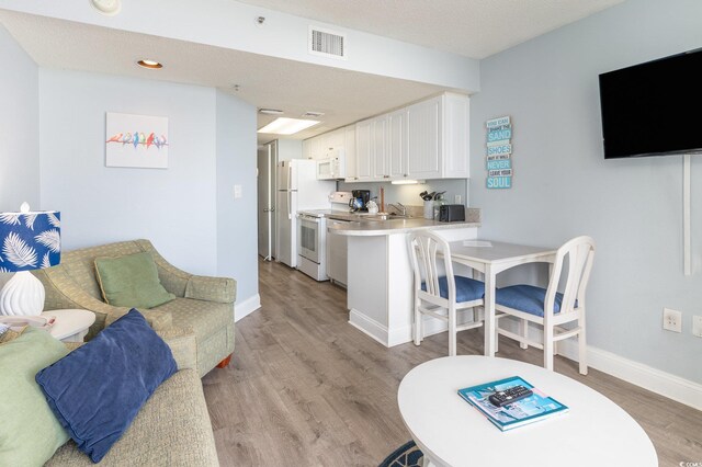 161 Seawatch Dr Unit 808, Myrtle Beach, SC 29572 - living area with visible vents, a textured ceiling, baseboards, and light wood-style floors