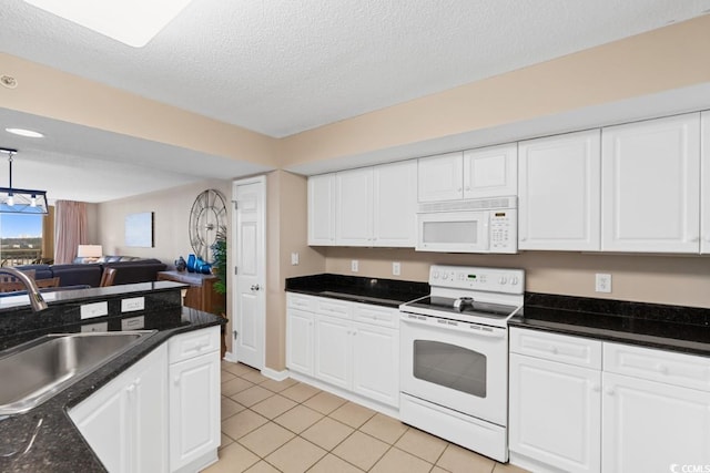 kitchen with open floor plan, white appliances, white cabinetry, and a sink