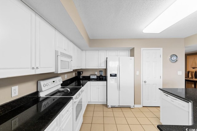 kitchen featuring dark stone counters, a textured ceiling, light tile patterned floors, white appliances, and white cabinetry