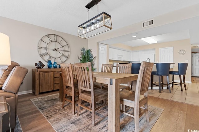 dining area featuring visible vents, baseboards, and light wood-style flooring