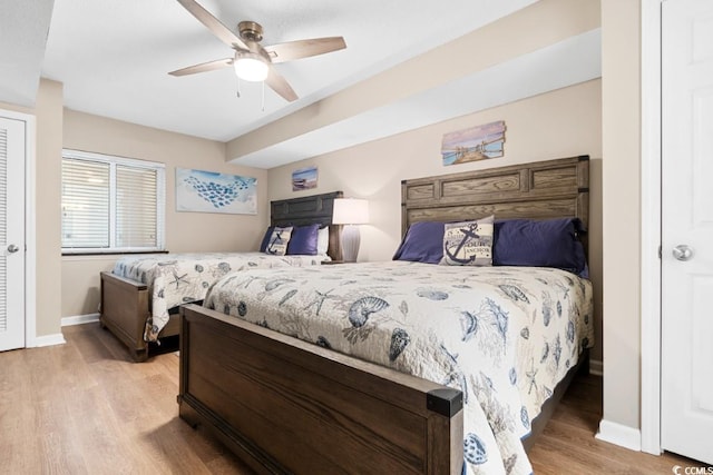 bedroom featuring baseboards, light wood-style floors, and ceiling fan