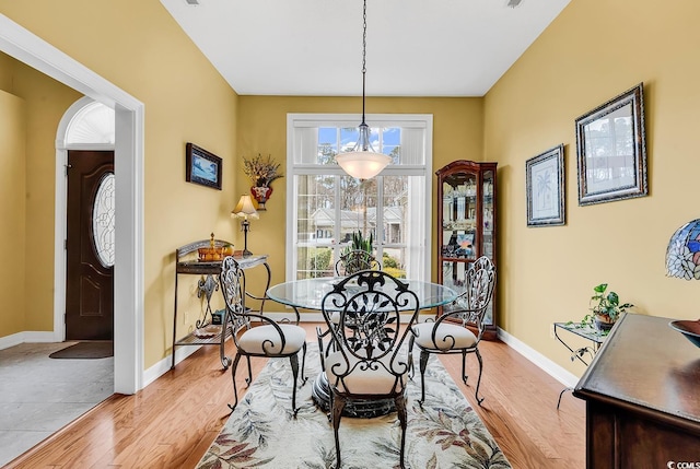 dining space featuring baseboards and light wood-style floors