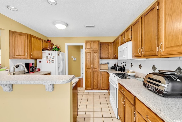 kitchen with white appliances, light tile patterned flooring, light countertops, and visible vents