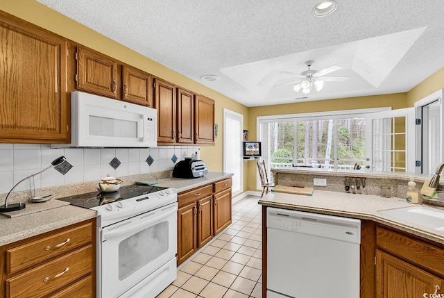 kitchen featuring a sink, white appliances, brown cabinetry, and light tile patterned floors