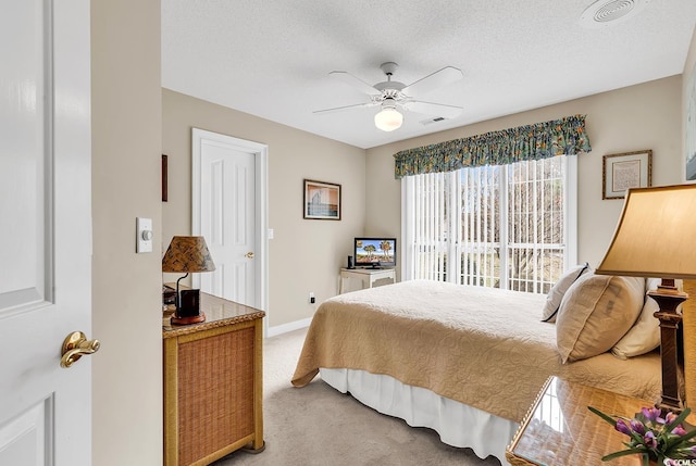 bedroom featuring visible vents, baseboards, light colored carpet, and a textured ceiling