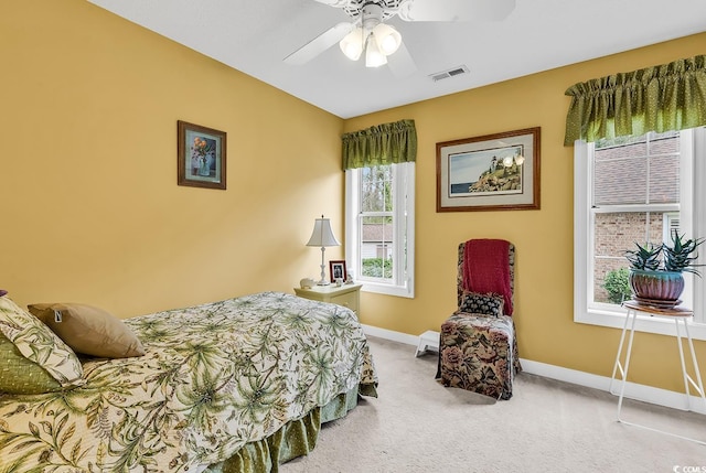 carpeted bedroom with visible vents, a ceiling fan, and baseboards