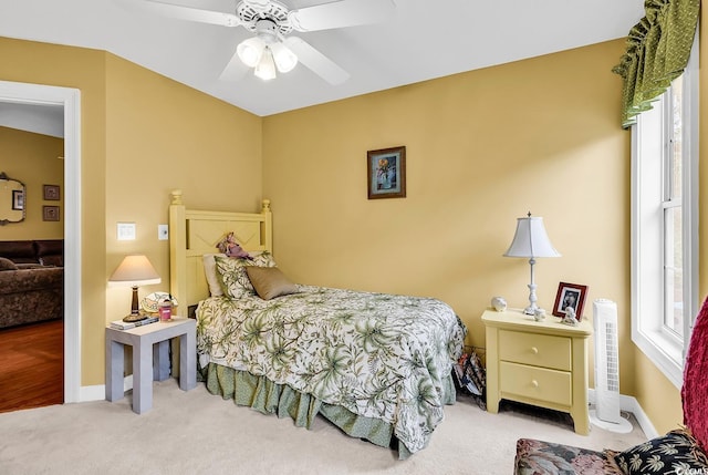 carpeted bedroom with baseboards and ceiling fan