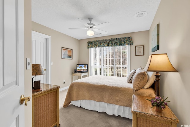 carpeted bedroom with baseboards, visible vents, a textured ceiling, and a ceiling fan