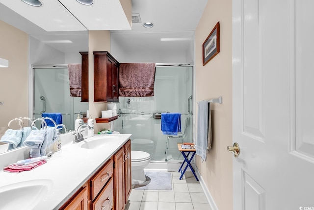 full bathroom with tile patterned floors, toilet, a stall shower, a sink, and double vanity