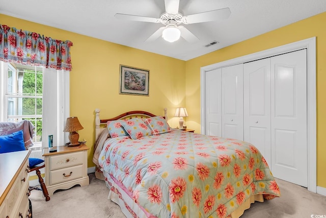 bedroom featuring a closet, visible vents, light colored carpet, and ceiling fan