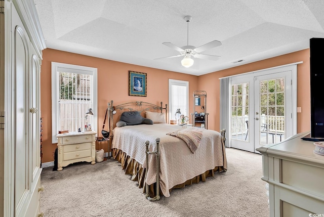 bedroom featuring access to exterior, french doors, light colored carpet, and a textured ceiling