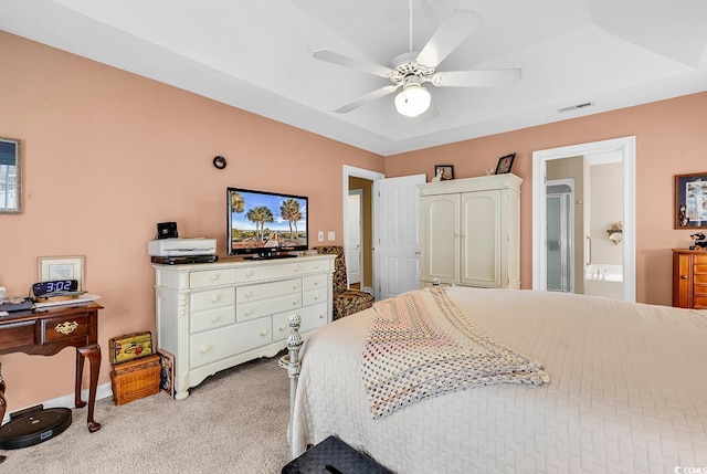 bedroom featuring baseboards, visible vents, ensuite bath, ceiling fan, and light colored carpet