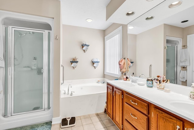 bathroom featuring tile patterned flooring, double vanity, a stall shower, a bath, and a sink