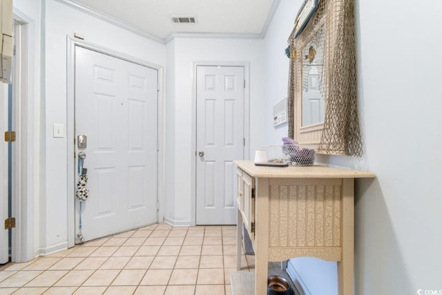 foyer with crown molding, light tile patterned floors, and visible vents