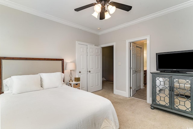 bedroom with light carpet, ornamental molding, baseboards, a ceiling fan, and ensuite bath