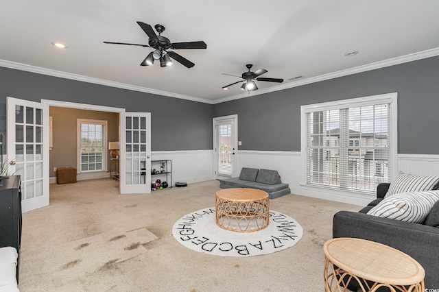 living room with french doors, a wainscoted wall, carpet flooring, and ornamental molding