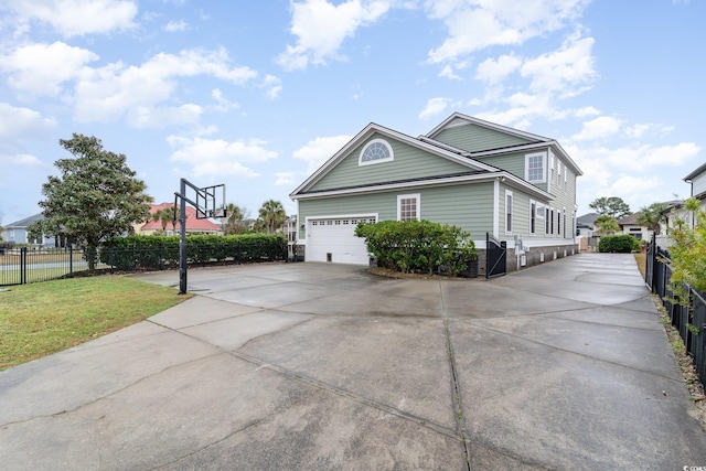 view of property exterior with an attached garage, fence, and driveway