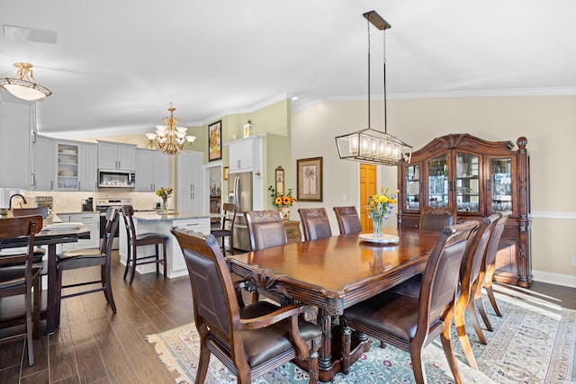dining space featuring a chandelier, vaulted ceiling, ornamental molding, dark wood-style flooring, and baseboards