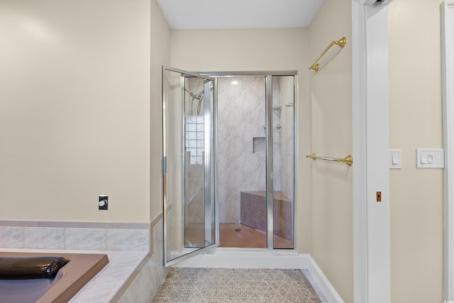 bathroom featuring a shower stall, a tub, and tile patterned flooring