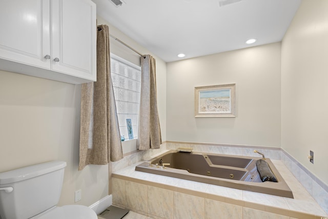 bathroom featuring toilet and a tub with jets