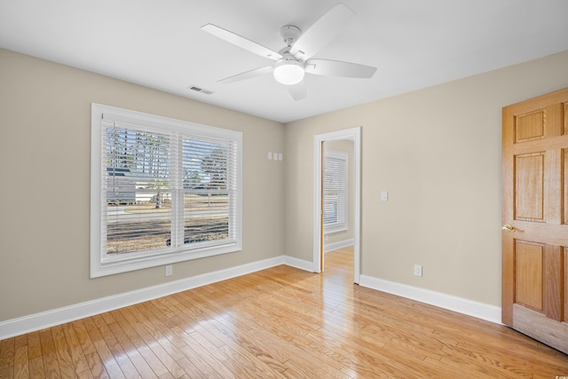 empty room with baseboards, light wood-type flooring, and ceiling fan