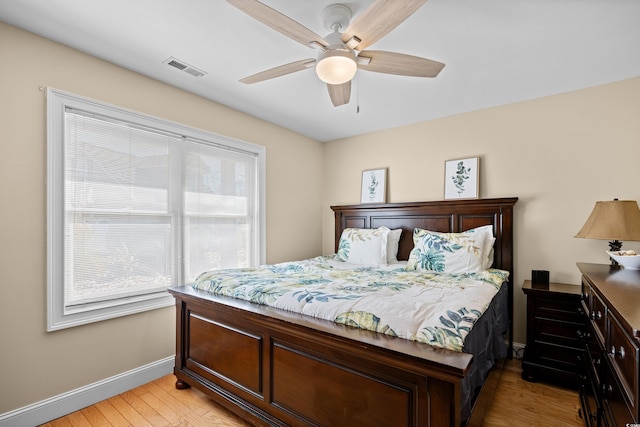 bedroom with baseboards, light wood-type flooring, and ceiling fan