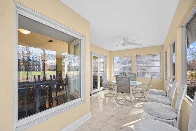 sunroom / solarium featuring tile patterned flooring and baseboards