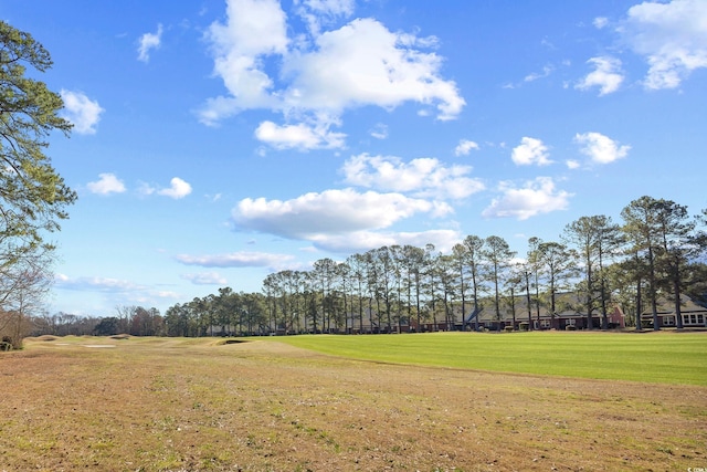 surrounding community with view of golf course and a lawn