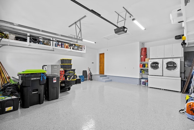 garage with washer and dryer and a garage door opener