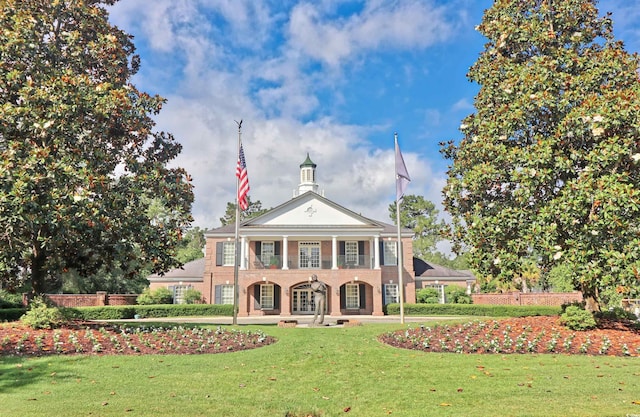 view of front facade with a front lawn, a balcony, and a porch