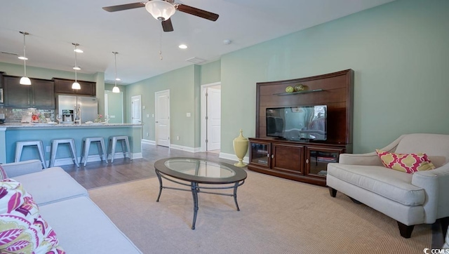 living area featuring ceiling fan, light wood-type flooring, recessed lighting, and baseboards