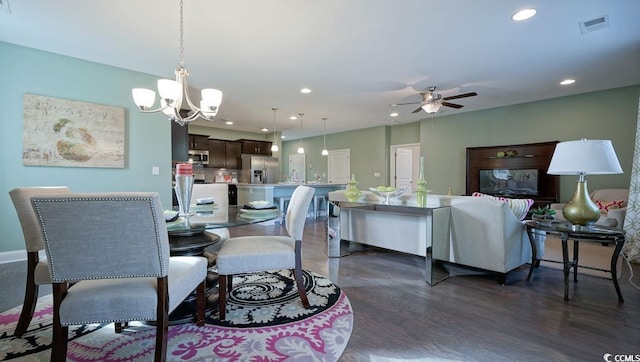 dining space featuring ceiling fan, recessed lighting, dark wood-style flooring, and a chandelier