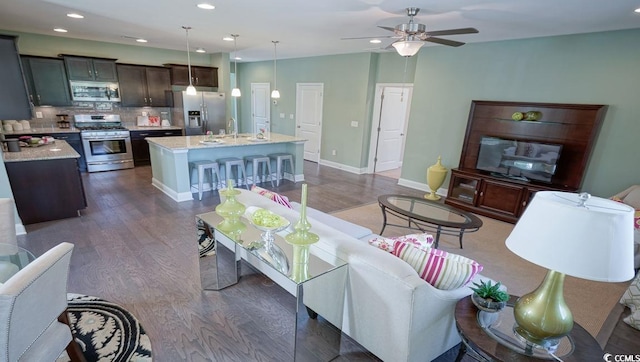 living room with dark wood finished floors, a ceiling fan, recessed lighting, and baseboards