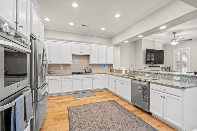 kitchen featuring a ceiling fan, visible vents, a sink, ornamental molding, and stainless steel appliances