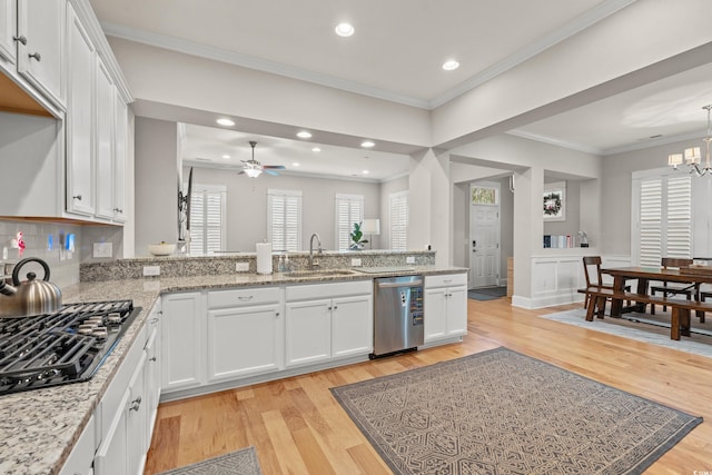 kitchen featuring a sink, dishwasher, crown molding, and light wood finished floors