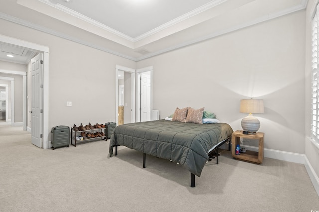 carpeted bedroom with ornamental molding, a tray ceiling, connected bathroom, baseboards, and attic access